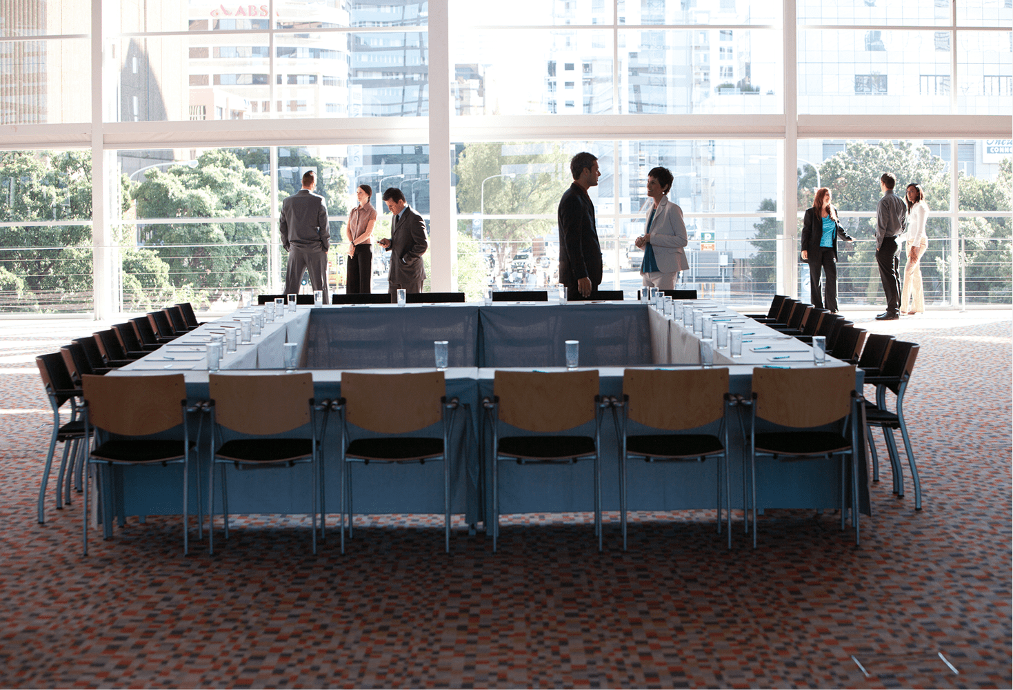Conference room with people standing around table.